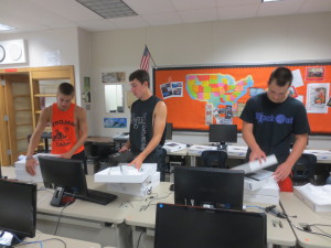 Volunteers from the York Suburban football work on sorting Chromebooks that will be distributed to students this year.  Students (from left):  Thomas Merkle, Brad Smith, and Derek Lehman.