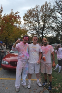 Teachers Steve Whiteley (left) and Oliver Good (right) are shown with student Evan Huber at the conclusion of Color Clash.  They are holding cups of color corn starch.