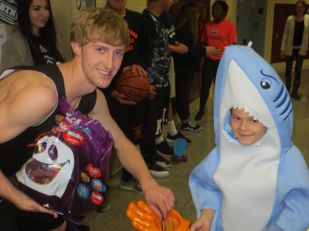 A shark collects a treat at one of the stops along the indoor York Suburban High School Trick or Treat Night.